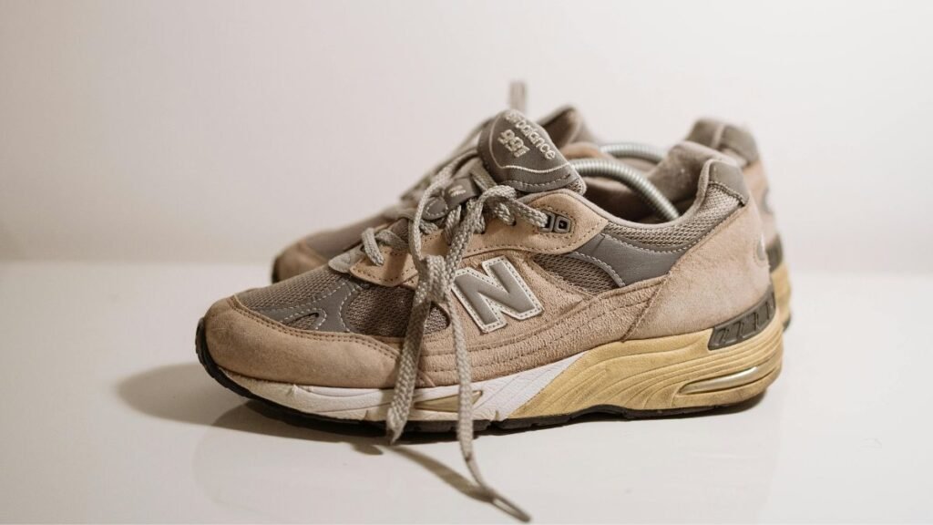 Worn beige New Balance sneakers.